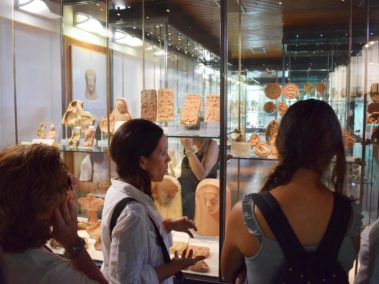Laura Danile con una famiglia davanti alla vetrina con i reperti di terracotta dal santuario ctonio al Museo Archeologico di Agrigento